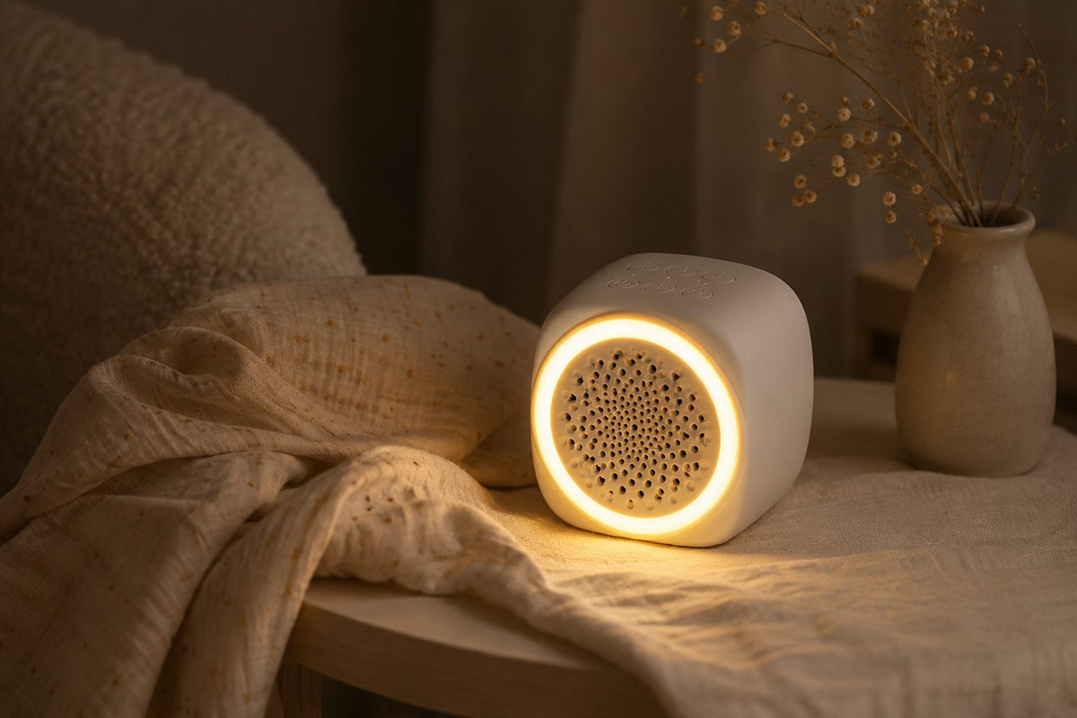 Le Cocon niché dans une gaze de coton beige près d'un fauteuil bouclé — ambiance enveloppante